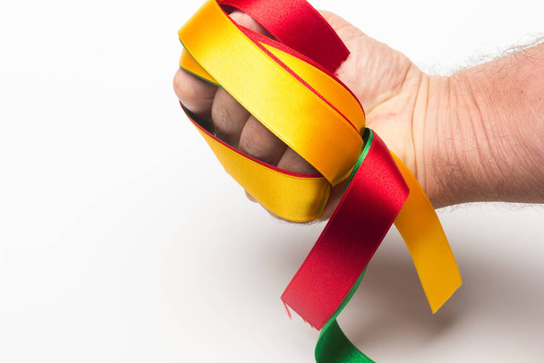 hand with coloured ribbon on white background; basic colours on an adult hand of a person. - Photo, Image