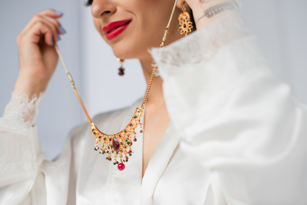 白のネックレスを持つ若いインドの花嫁のクロップドビュー - 写真・画像