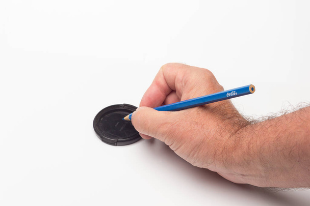 Värillinen lyijykynä valkoisella pohjalla piirroksen tai kirjaimen aloittamiseksi tai mittasuhteiden mittaamiseksi; kynä, jota käytetään viivoittimena. - Valokuva, kuva