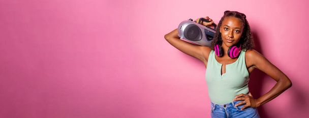 Junge schwarze Frau isoliert Musik hören mit Boombox suchen Kamera vertrauen - Copyspace Werbebanner - Foto, Bild