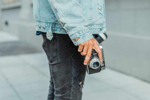 A young Caucasian male photographer holding his camera - Fotó, kép