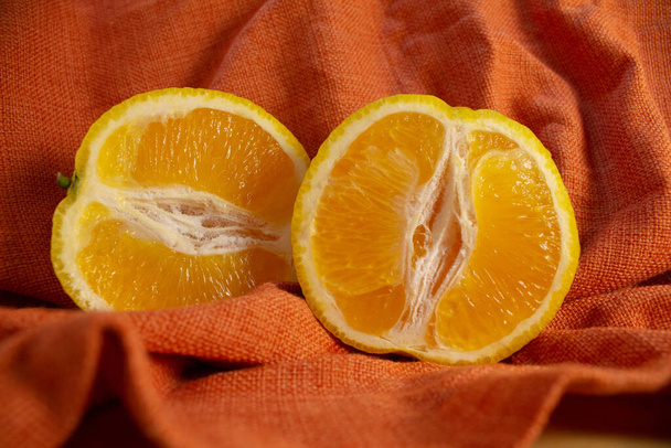 Pomarańczowe połówki na czerwonym tle - Zdjęcie, obraz
