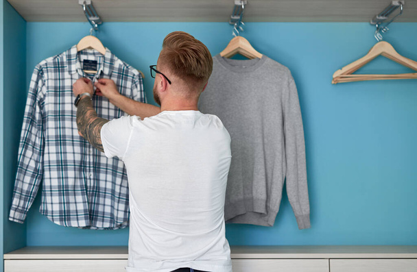 Man organizing garments in wardrobe - Foto, Imagem