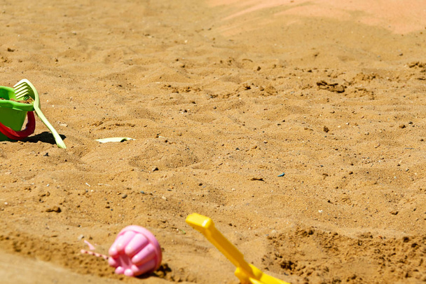 Zabawki dla dzieci na żółtym piasku. Pojęcie rekreacji plażowej dla dzieci. Letnie zabawy dla dzieci. Koncepcja letnia, przestrzeń kopiująca - Zdjęcie, obraz
