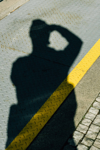 A vertical shot of the ground with the shadow of the photographer under bright sunlight - Fotografie, Obrázek