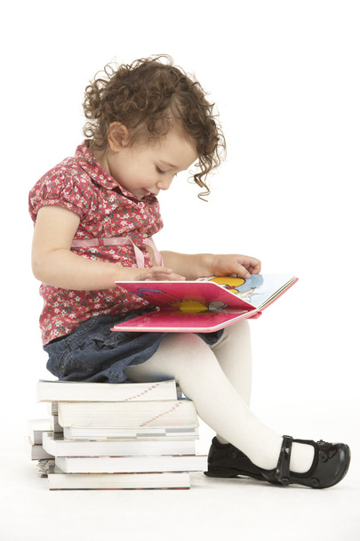 Young Girl Sitting On Pile Of Books Reading - Foto, immagini