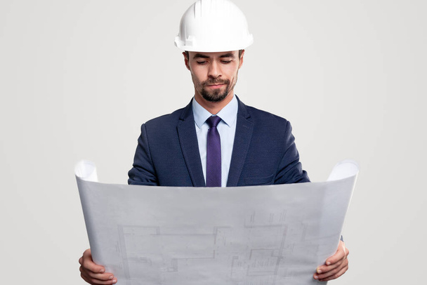 Serious male architect examining blueprint - Фото, зображення
