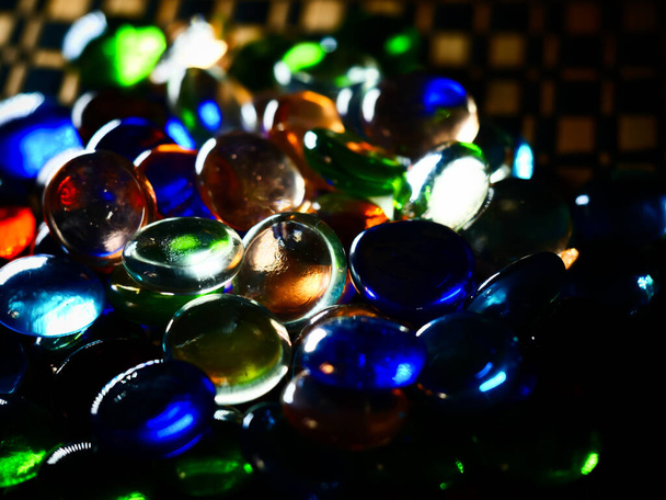 A group of colorful clear gems with neon lights reflecting on them on a blurry background - Foto, afbeelding