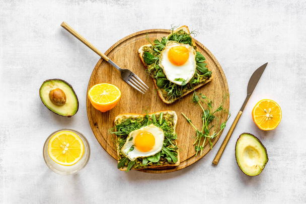 Toasts with eggs and avocado cream and spinach. Top view - Φωτογραφία, εικόνα