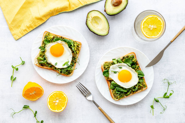 Toasts with avocado and fried eggs. Healthy breakfast - Fotoğraf, Görsel