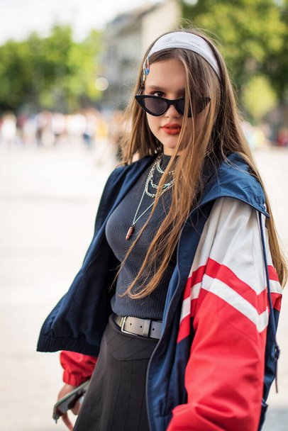 Beautiful country girl in 90s style. Back in time 90s 80s. Stylish girl in retro colourful vintage coat. dressed in street style clothes with chains around neck for a walk. Youth and lifestyle concept - Фото, изображение