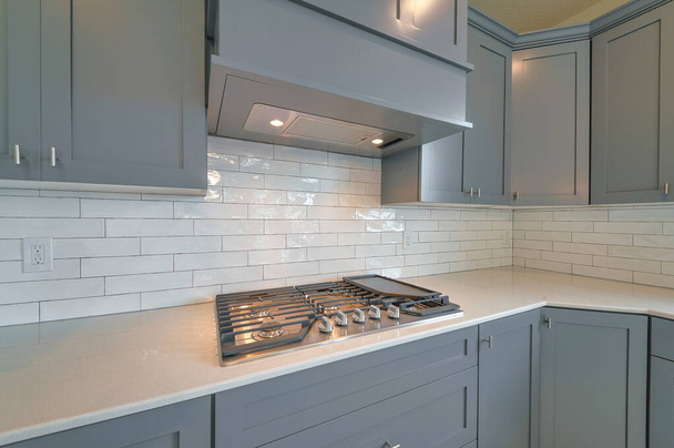 Fehér és szürke konyha belsejében otthon tűzhely rögzített a pulton - Fotó, kép
