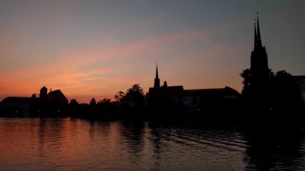 Prachtige zonsondergang aan de oevers van de rivier in de stad - Video