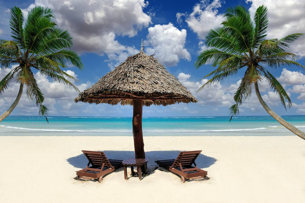 Hermosa playa tropical witn sombrilla de paja y palma. Sombrilla de paja y palmera en la playa - Foto, imagen
