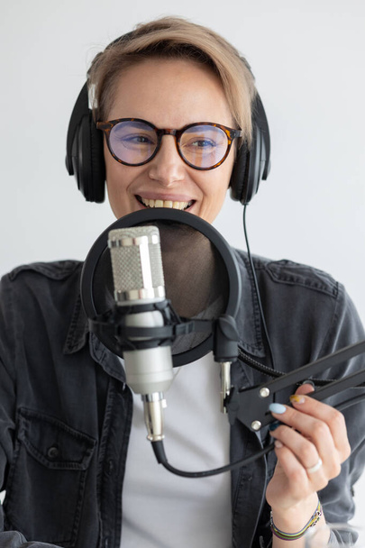 Young and confident European woman recording a podcast in a recording studio - Фото, зображення