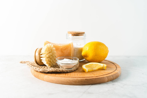Eco friendly natural cleaners, jar with baking soda, dish brush, lemon, soap on white marble table background. Organic ingredients for homemade cleaning. Zero waste concept - Photo, Image