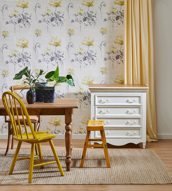 Modern wallpaper background in the room, wooden furniture table chair concept and cabinet, yellow carpet and green vase of plant. - Photo, Image