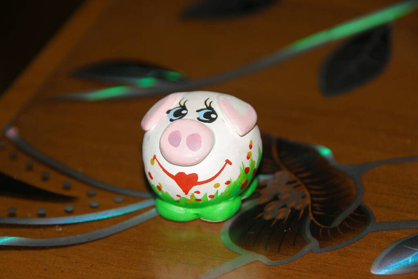 Маленька кольорова іграшкова скульптурна свиня
 - Фото, зображення