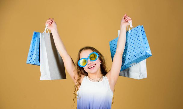Black friday. Sale discount. Shopping day. Child fashion girl sunglasses hold package. Favorite kids brand. Girl with shopping bag. Shopping tour abroad. Summer season sale. Shopping and purchase - Foto, Bild