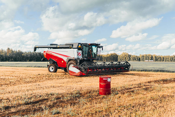 Combine harvester in a field against a background of blue sky. autumn harvest - Foto, afbeelding