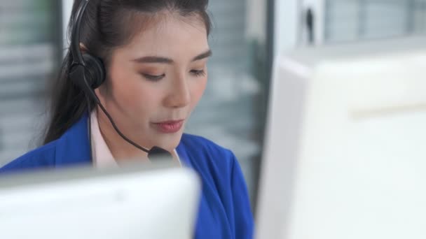 Businesswoman wearing headset working actively in office - Footage, Video