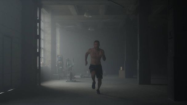 Hombre deportivo empezando a correr en el gimnasio. Chico calentando cuerpo antes de crossfit ejercicio - Foto, Imagen