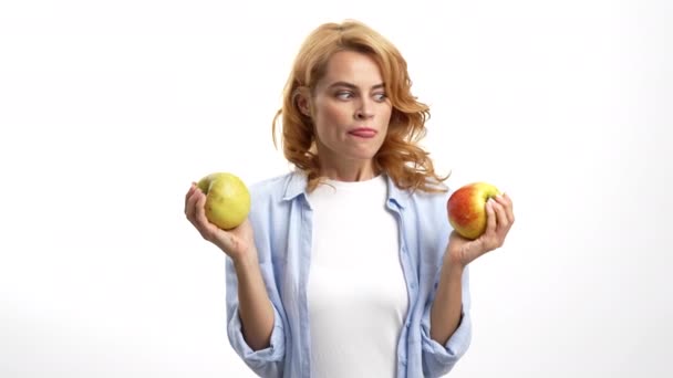 hongerige vrouw kiezen appel likken haar lippen en bijten fruit, honger - Video