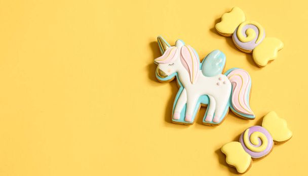 Beautiful gingerbread cookies for children's party in the shape of a unicorn and sweets, flat lay. - Photo, Image