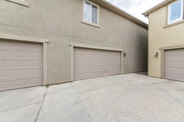 Exterior of two buildings with concrete driveway, garage doors and windows - Photo, Image