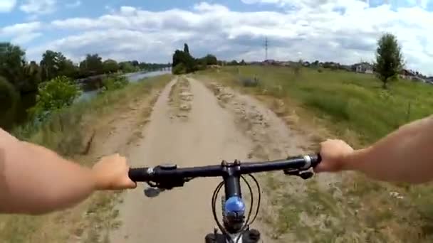 Homem montando uma bicicleta em um campo em uma grama verde - Filmagem, Vídeo