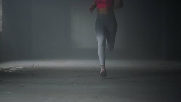 Nogi sportowca biegają szybko na siłowni. Kobieta robi trening cardio w budynku poddasza - Zdjęcie, obraz
