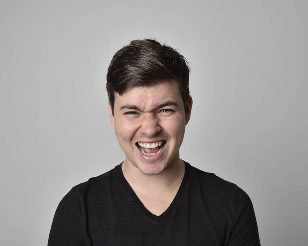Close up head and shoulders portrait of a brunette. young man with a variety of expressive facial expressions. Isolated on a light grey studio background. - Photo, Image