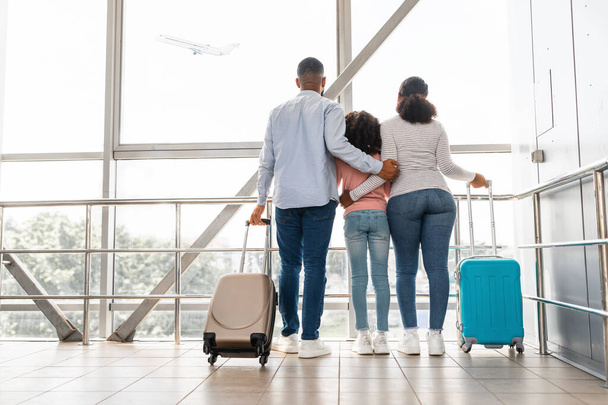 Schwarze Familie reist und wartet auf die Ankunft des Flugzeugs - Foto, Bild