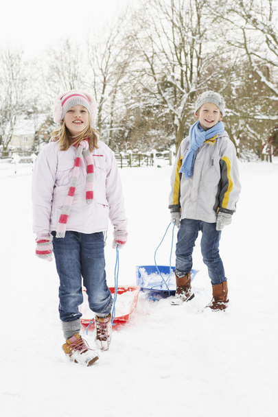 Children Pulling Sledge Through Snowy Landscape - Zdjęcie, obraz