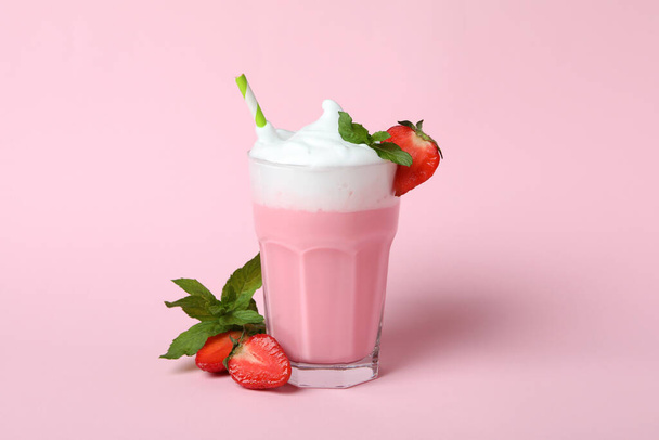 Glass of strawberry milkshake and ingredients on pink background - Fotografie, Obrázek