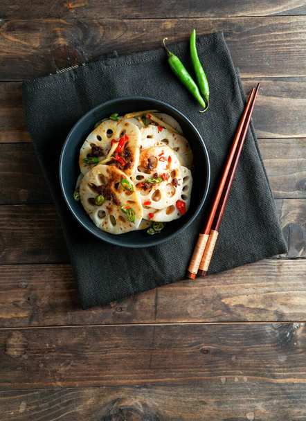 ensalada de raíz de loto picante en el fondo de piedra blanca, comida asiática - Foto, Imagen