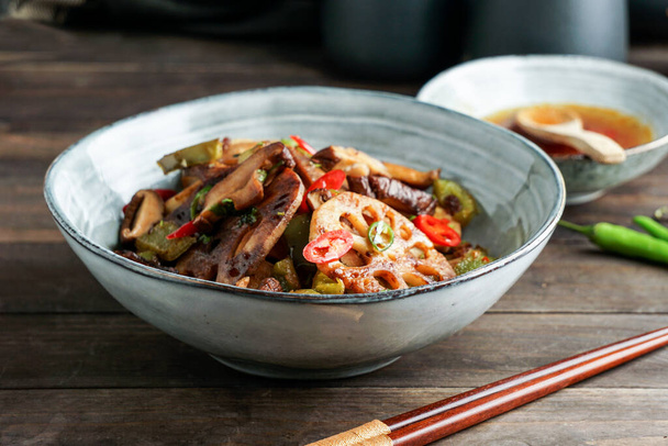 Lotus root or Rhizome stir-fry with Shiitake mushrooms, spices, hot peppers, dark soy sauce and green onions - Foto, immagini