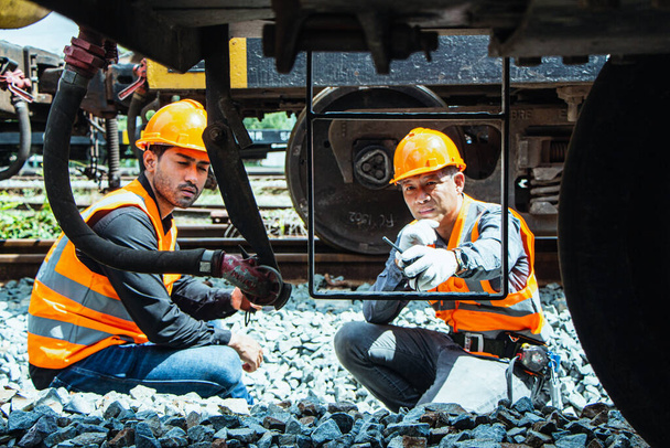 Inspecteur Engineering draagt helm en vest werknemer unifrom het controleren van de bouw van spoorwegen op spoor. - Foto, afbeelding