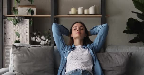 Carefree peaceful young beautiful woman relaxing on comfortable sofa. - Materiał filmowy, wideo