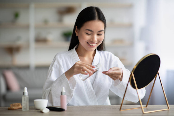 Hübsch jung asiatisch frau cleaning sie gesicht mit toner - Foto, Bild