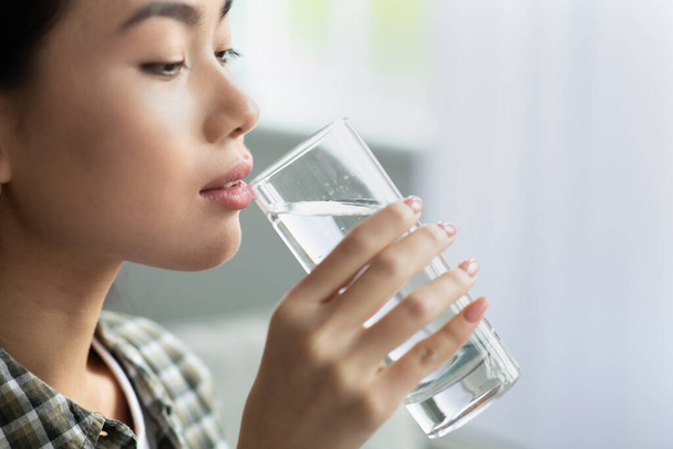 Asyalı bir kadının kaynak suyu içtiği yakın plan. - Fotoğraf, Görsel