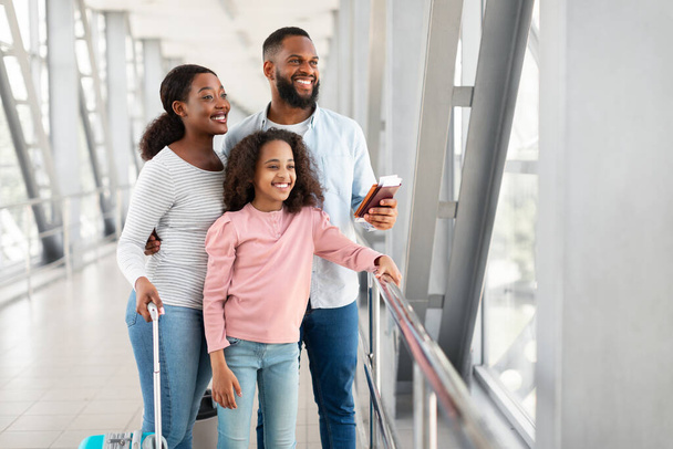 Schwarze Familie reist und wartet auf die Ankunft des Flugzeugs - Foto, Bild