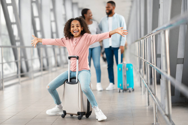 Happy black girl playing and having fun in airport - 写真・画像