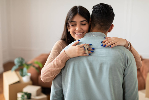 Happy couple hugging and showing keys of their apartment - Photo, Image