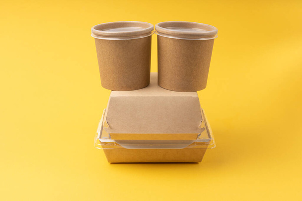 Disposable food delivery boxes on yellow background - Фото, изображение