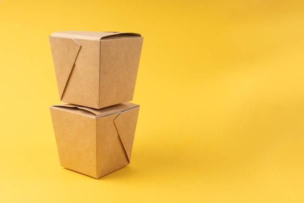 Disposable food delivery boxes on yellow background - Fotó, kép