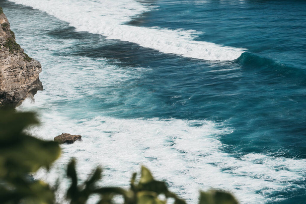 Ωκεάνια κύματα συντρίβονται στη βραχώδη ακτή κατά τη διάρκεια της ημέρας στο Μπαλί, Ινδονησία - Φωτογραφία, εικόνα