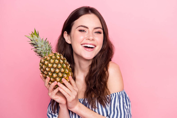 Photo of impressed funny young woman dressed striped outfit holding fruit laughing isolated pink color background - Фото, изображение