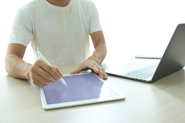 close-up de um homem usando um computador tablet e um dispositivo digital - Foto, Imagem