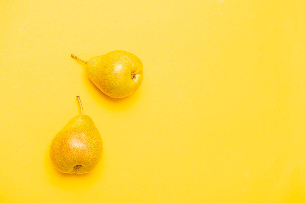 新鮮な熟した梨と黄色の色の背景にテキストのためのスペースとフラットレイアウトの組成物 - 写真・画像